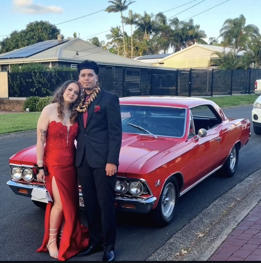 Couple in red beside the Chevelle